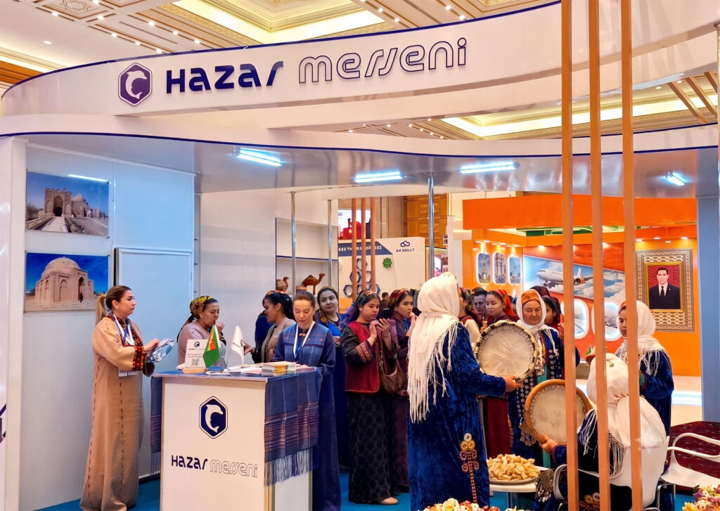 Representatives of Hazar Merjeni DMC presenting Turkmenistan travel services and Silk Road tour packages at an international tourism exhibition.